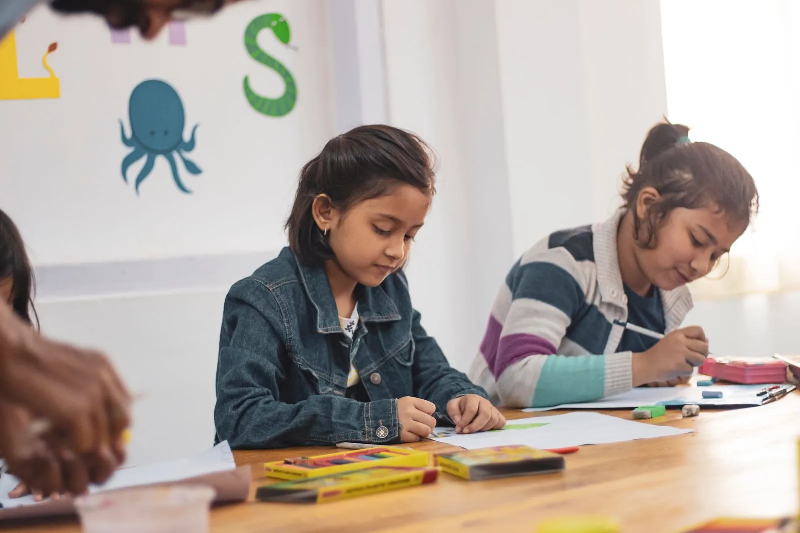 A child quietly focused on drawing at a desk